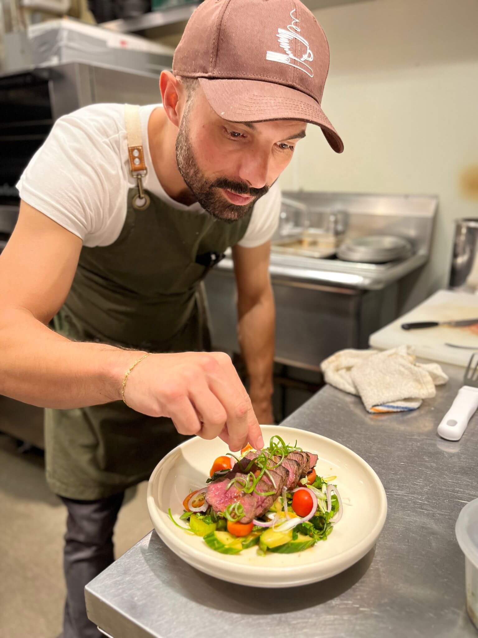Chef Aguinaldo Monteiro preparing a fine dining dish in Boston